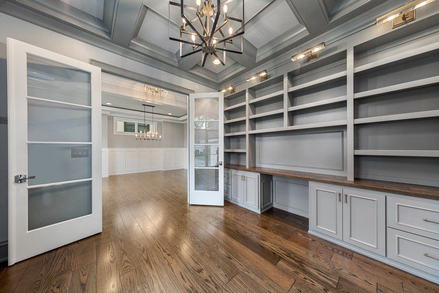 A large empty room with lots of shelves and a chandelier.