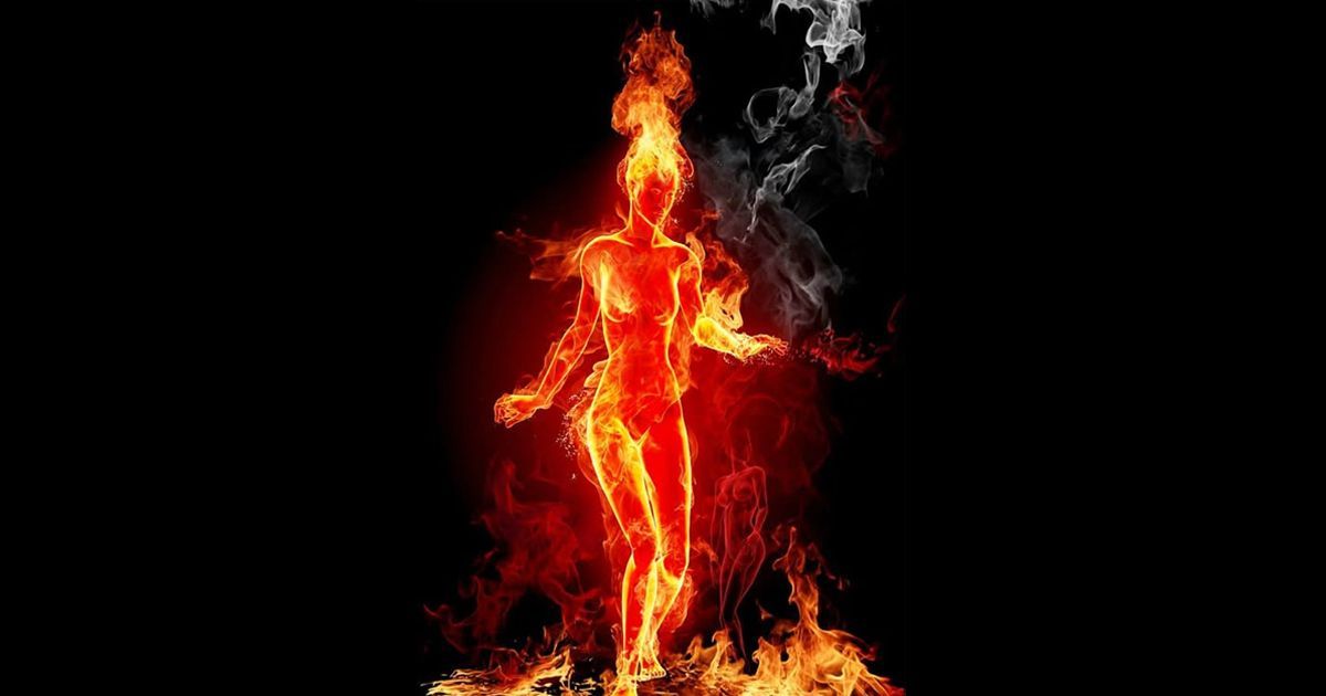 Fiery woman dancing, engulfed in flames against a black background.