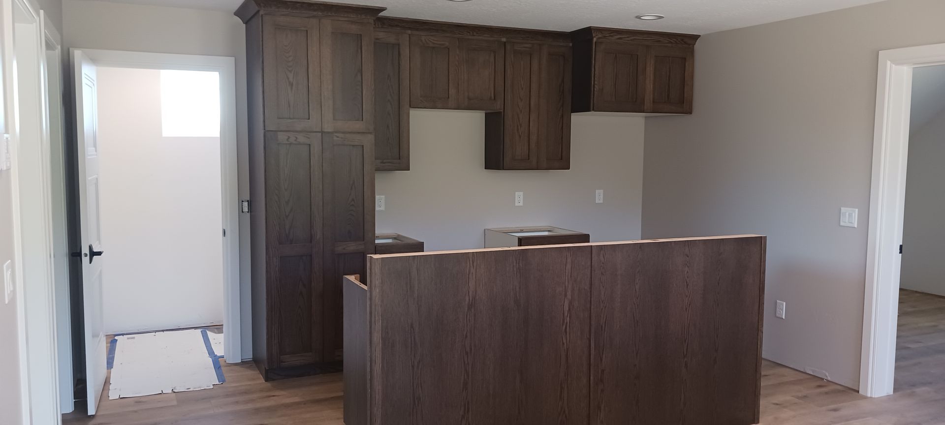 An empty kitchen with wooden cabinets and a large island.