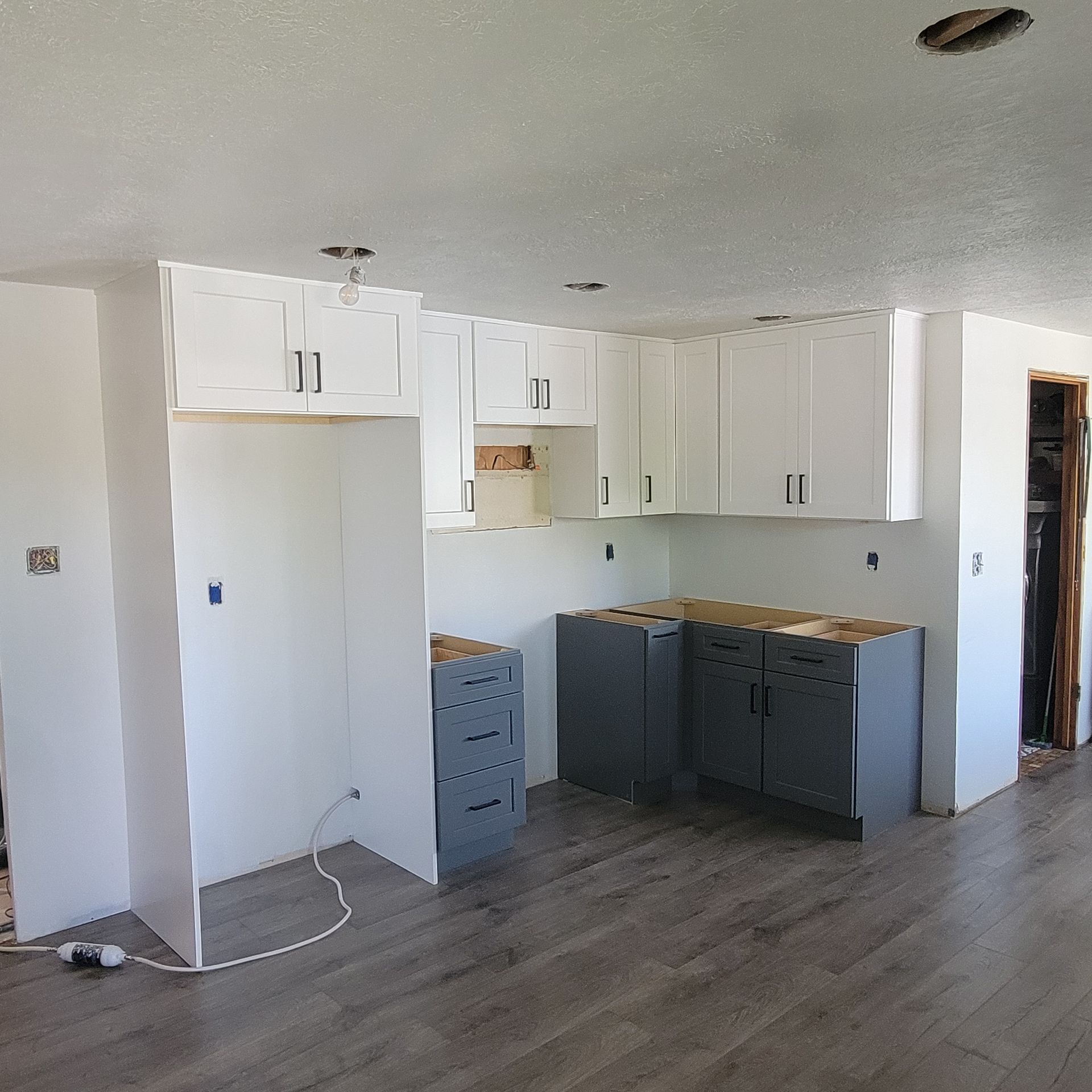 A kitchen with white cabinets and gray cabinets