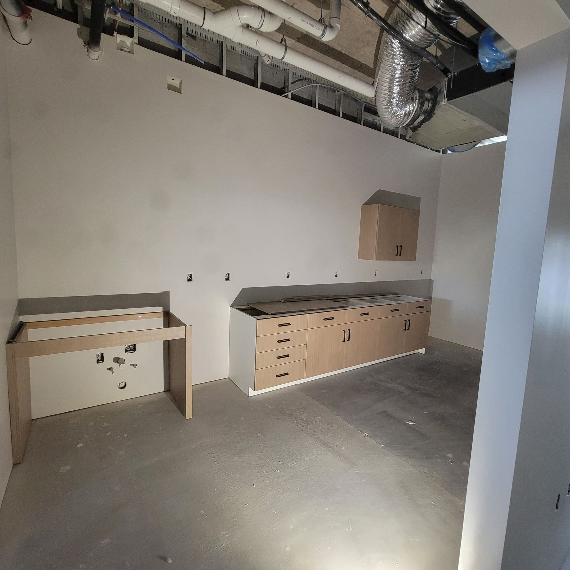 An empty room with white walls and wooden cabinets