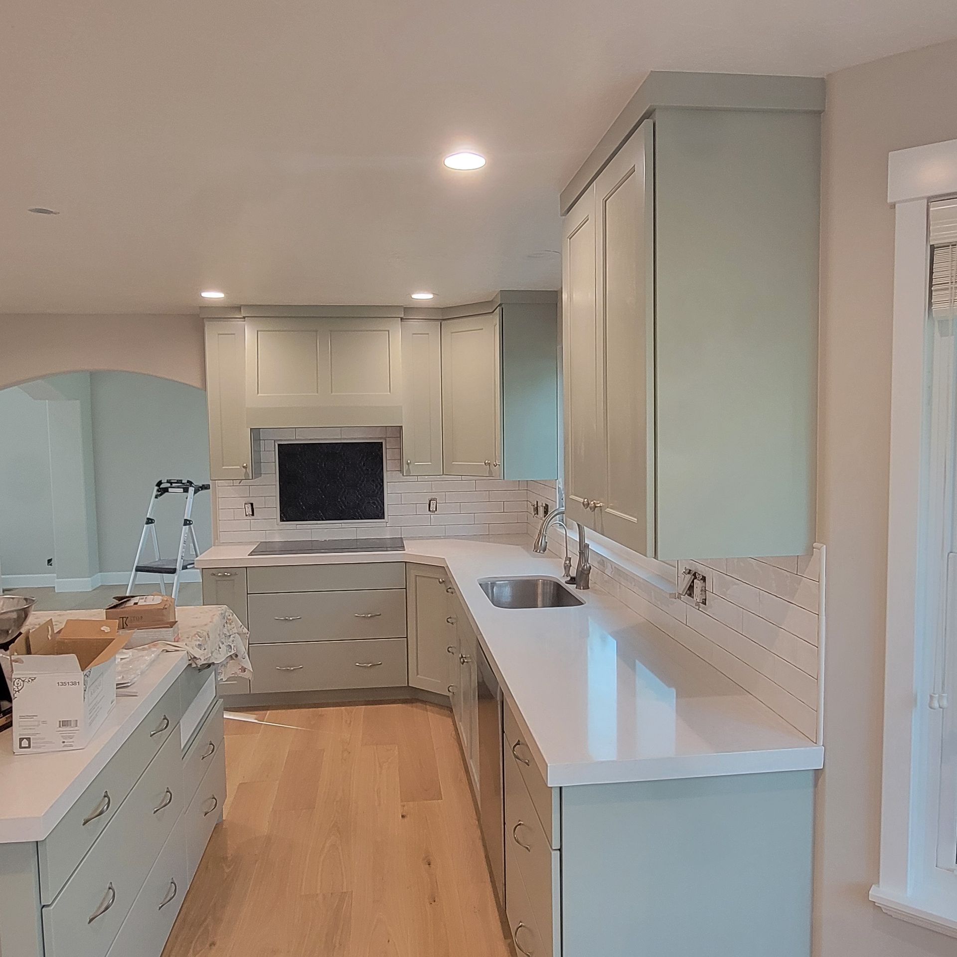 A kitchen with white cabinets and a sink