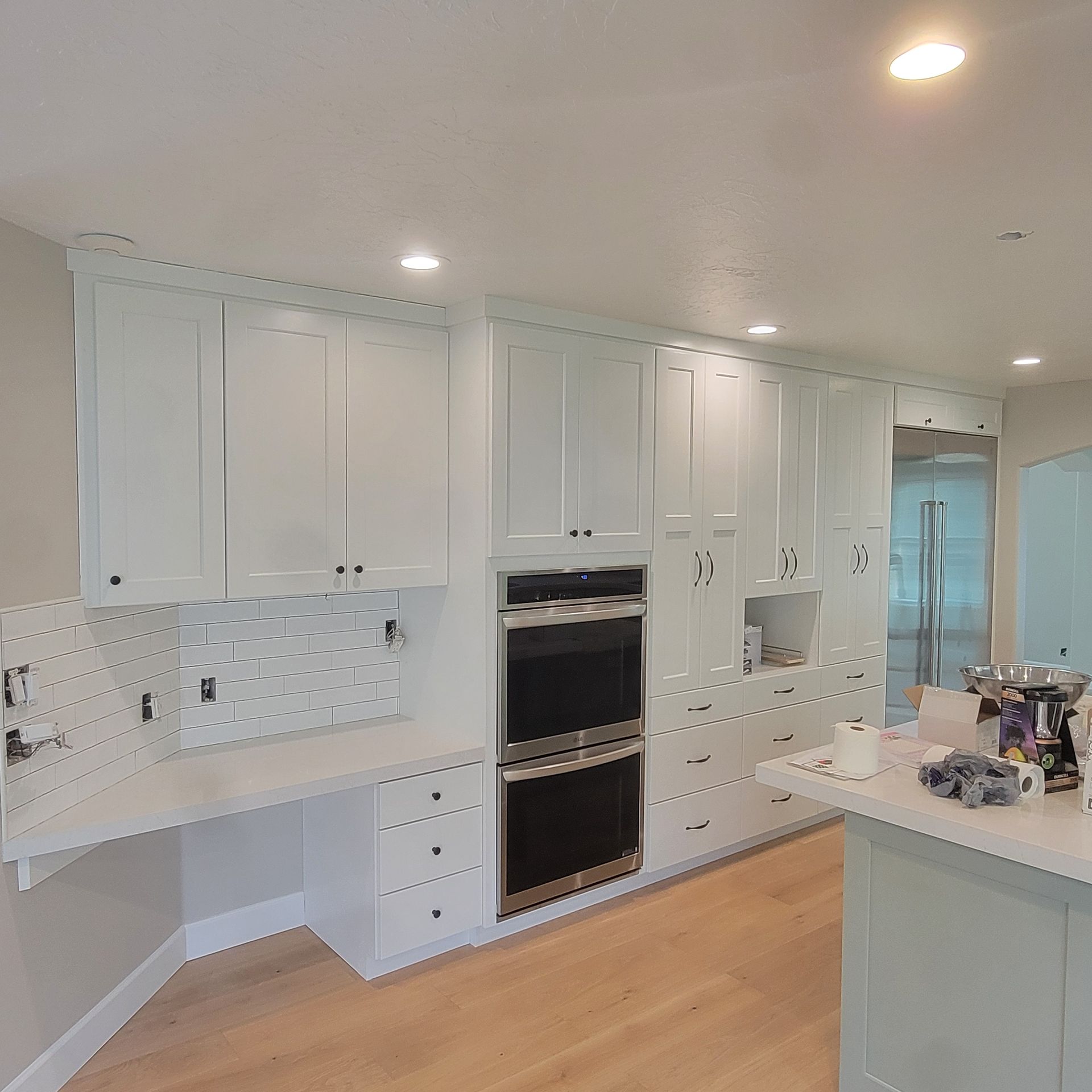 A kitchen with white cabinets and stainless steel appliances