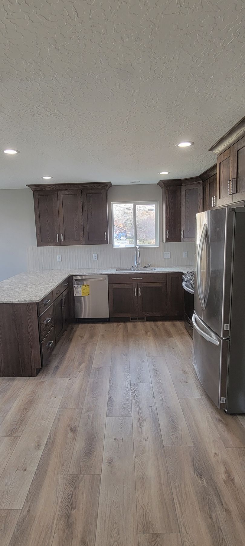 A kitchen with stainless steel appliances and wooden floors.