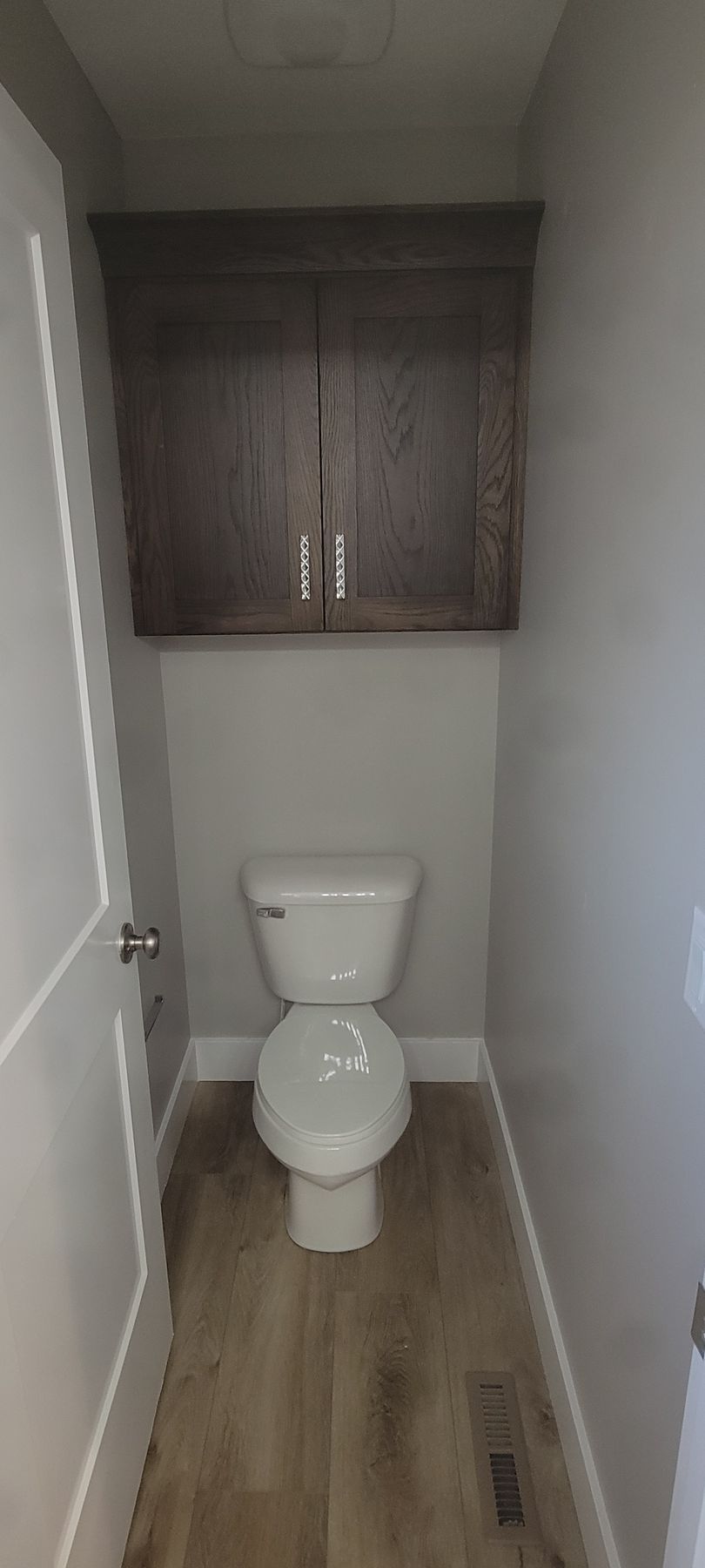 A toilet is sitting in a small bathroom next to a door.