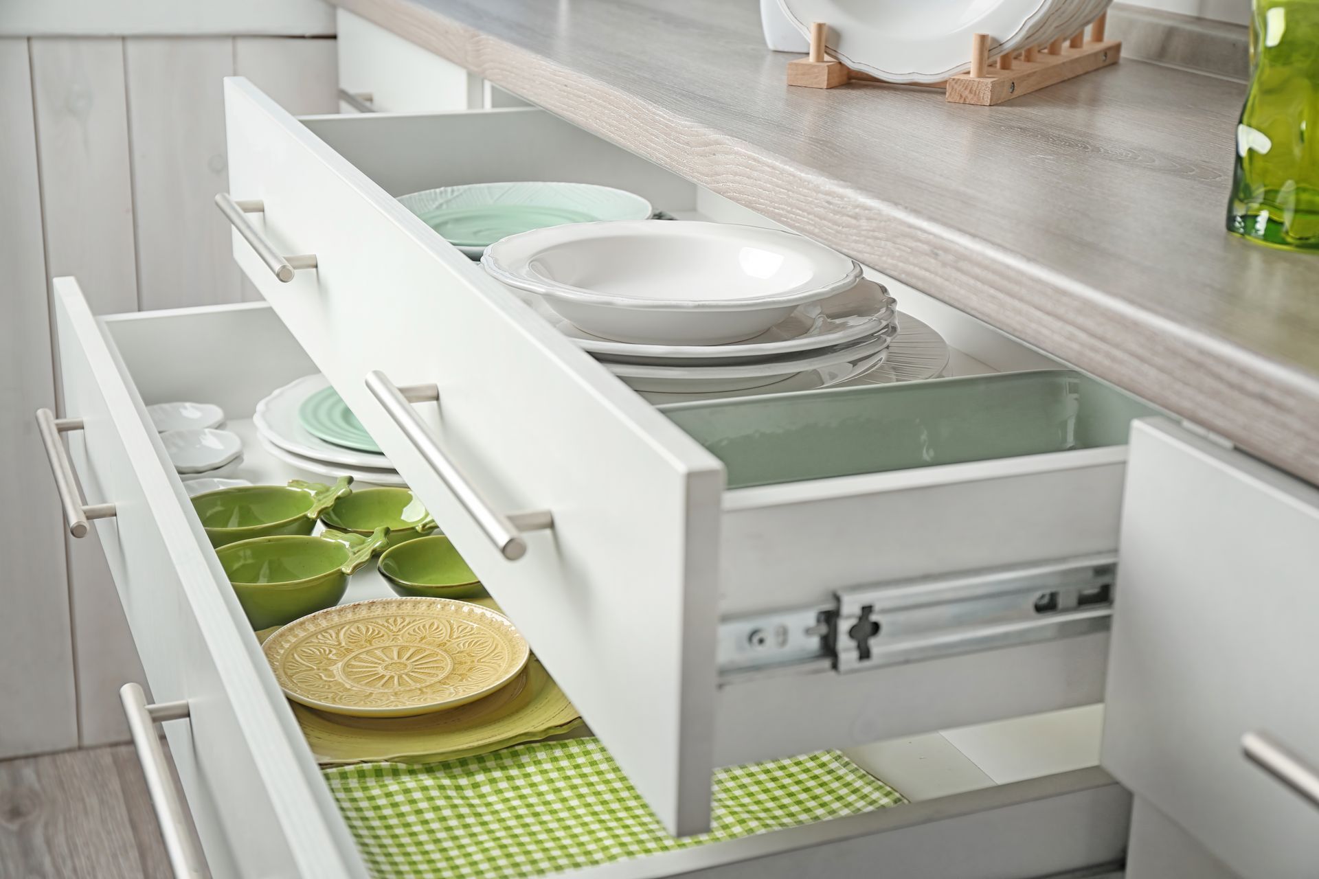 Open kitchen drawers filled with plates and bowls.