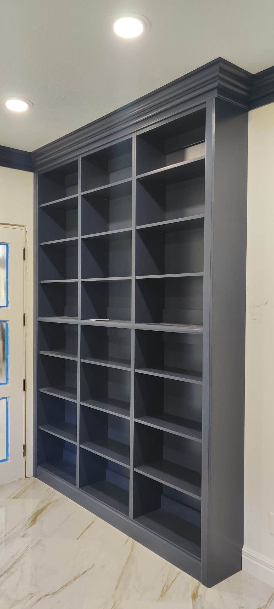 A large bookshelf with lots of shelves in a room.