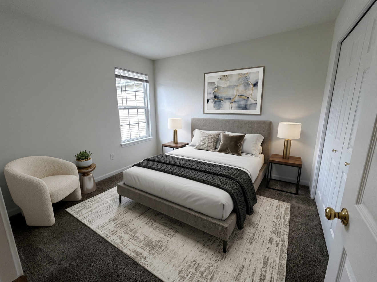 Bright modern bedroom with a bed, armchair, nightstands, and a window with white blinds