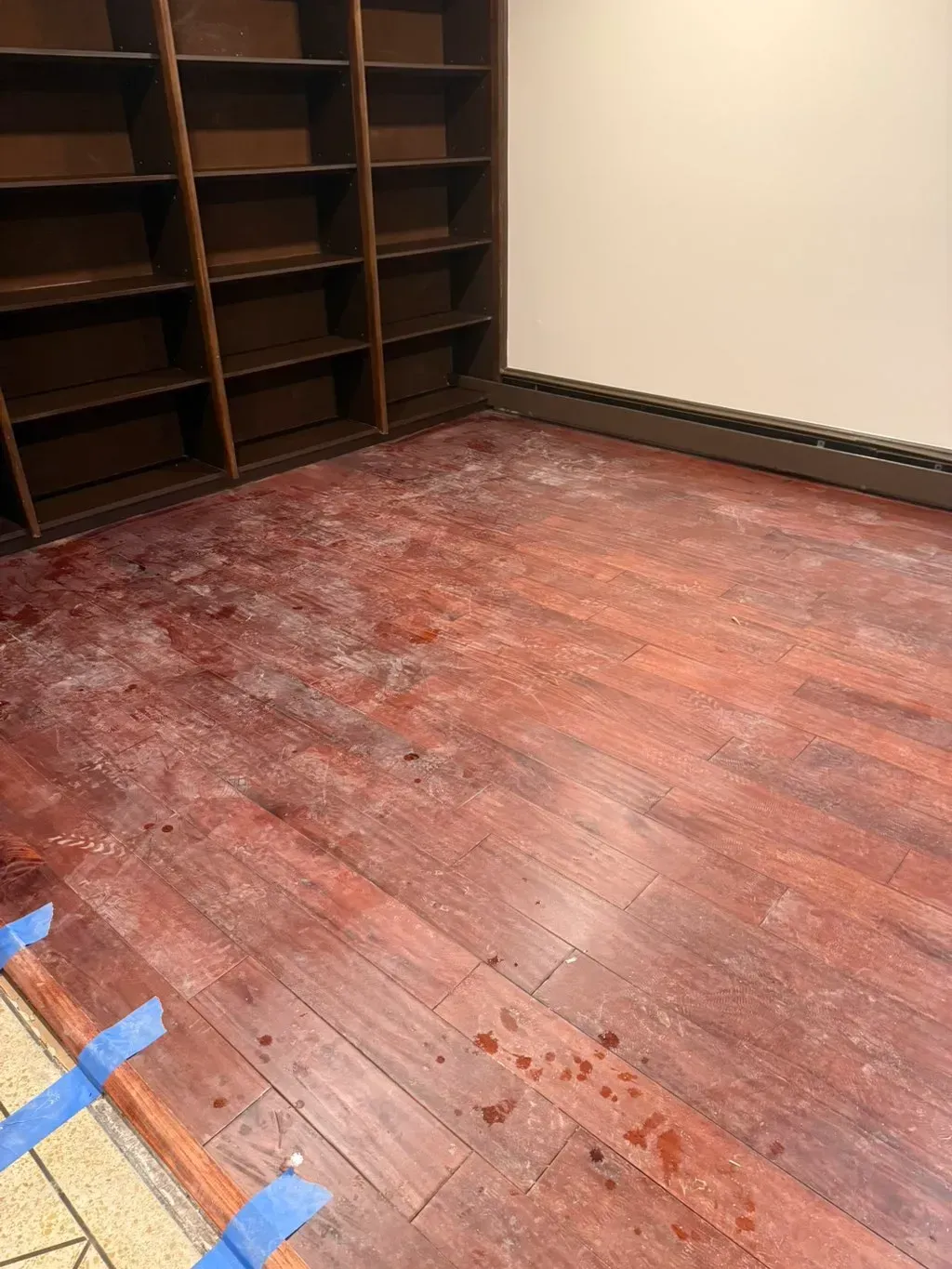 A room with a wooden floor and shelves.