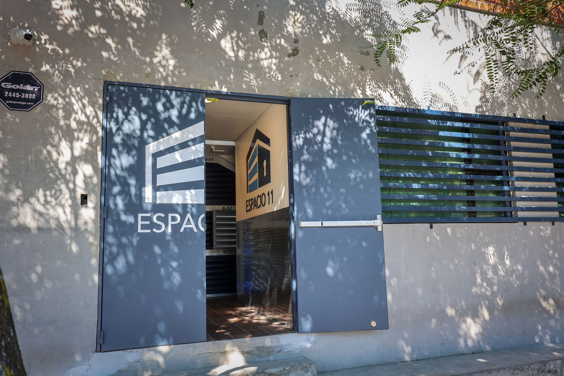 Teclado de sistema de seguridad de color blanco para pared, que muestra la hora y la dirección, con botones numerados y teclas de función.