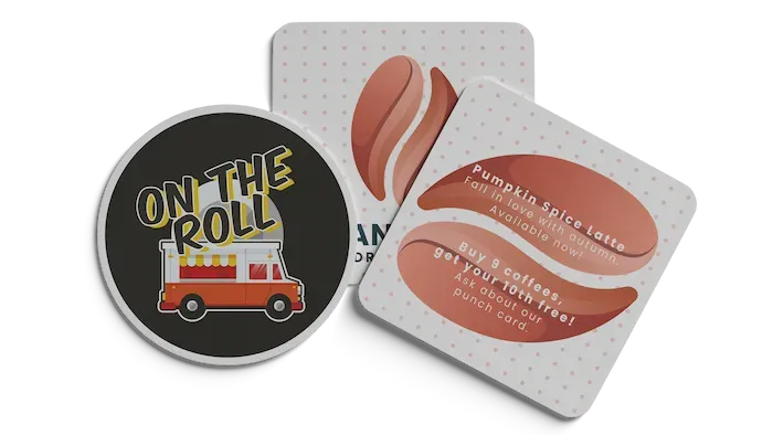 Three food-related coasters: one round with a food truck, two square with stylized coffee beans.