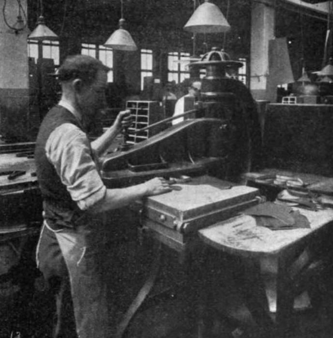 A black and white photo of a man working on a machine