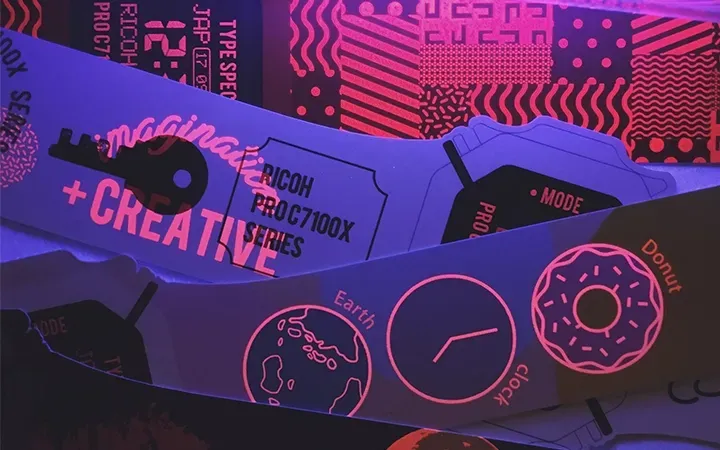 Bright neon-lit design elements, including a key, a donut, and text, glowing under blacklight.