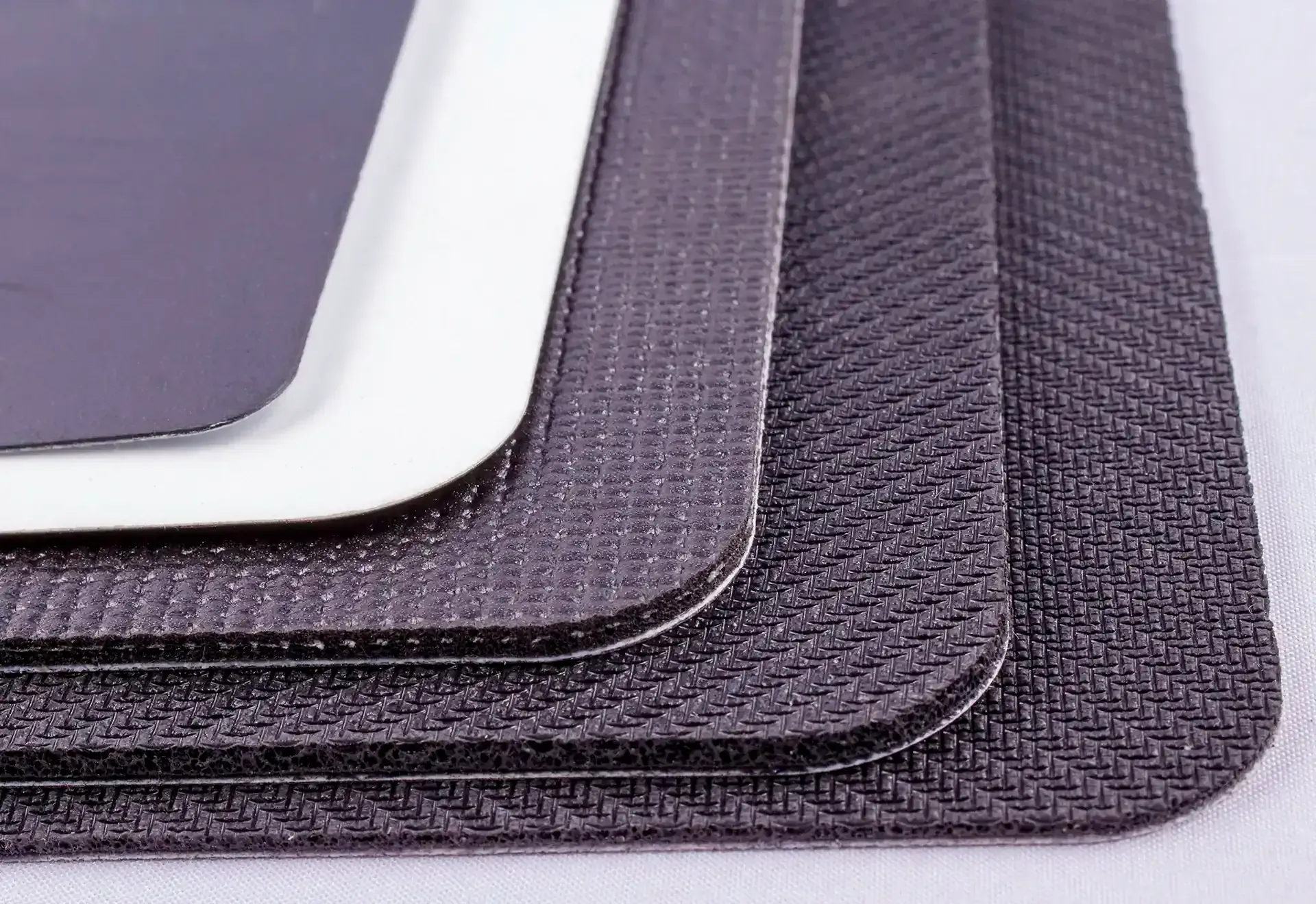 Stack of place mats in varying textures and dark colors.