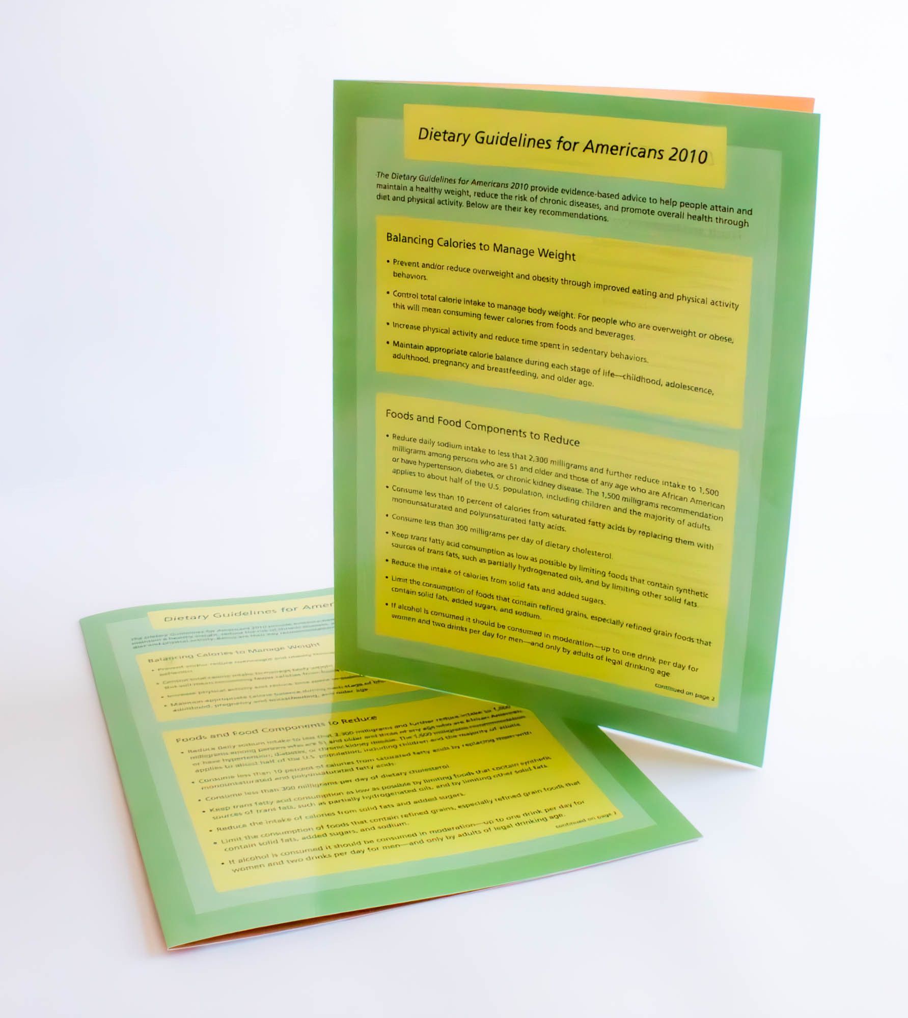 A green brochure with a yellow sticker on it