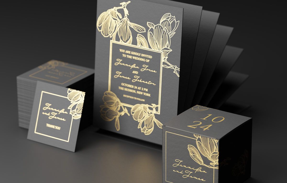 A black and gold wedding invitation is sitting on top of a table.