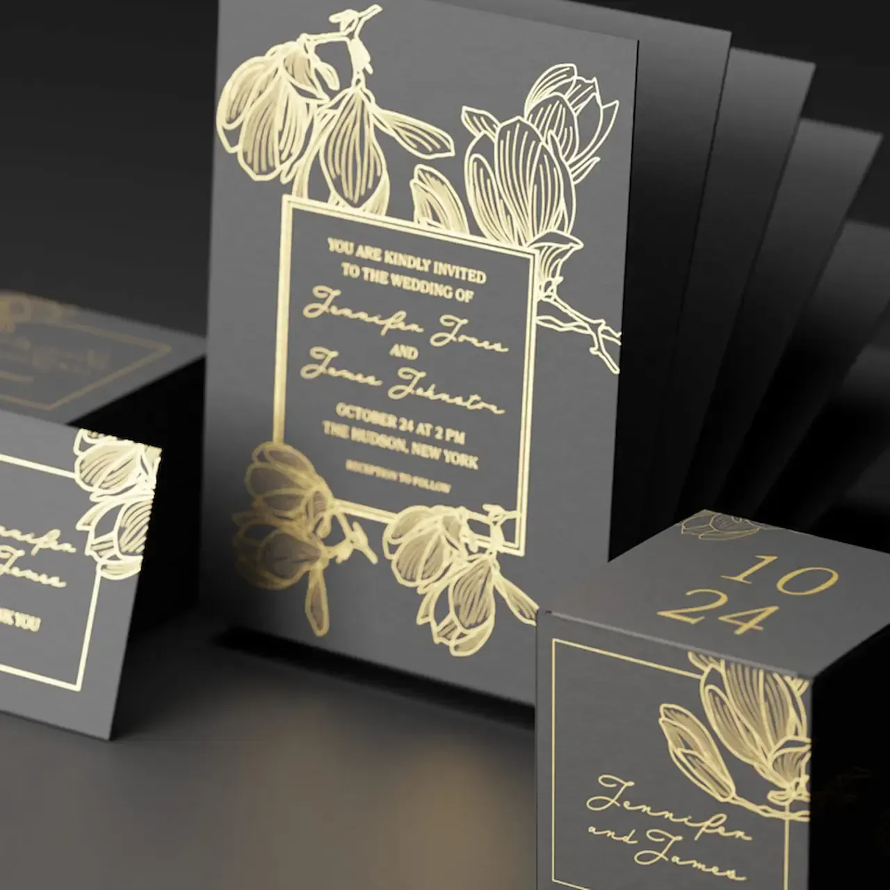 Gold-foil floral design on dark gray stationery set: invitations and a date block.