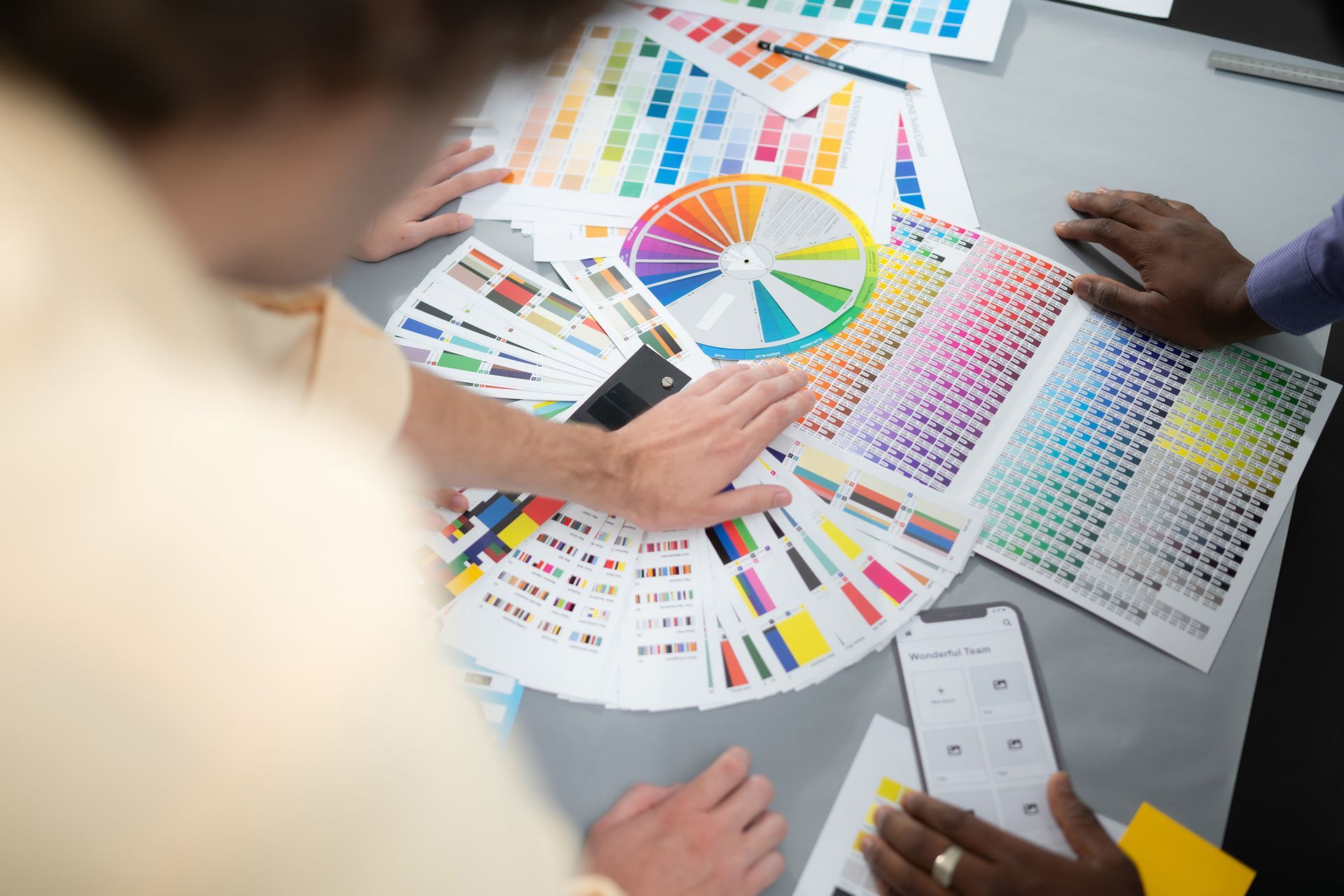 A group of people are sitting around a table looking at a color wheel.