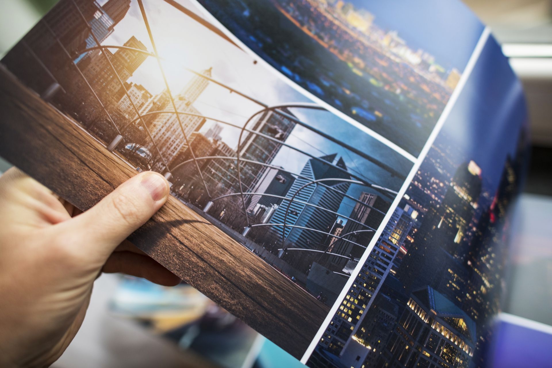 A person is holding a picture of a city in their hand.