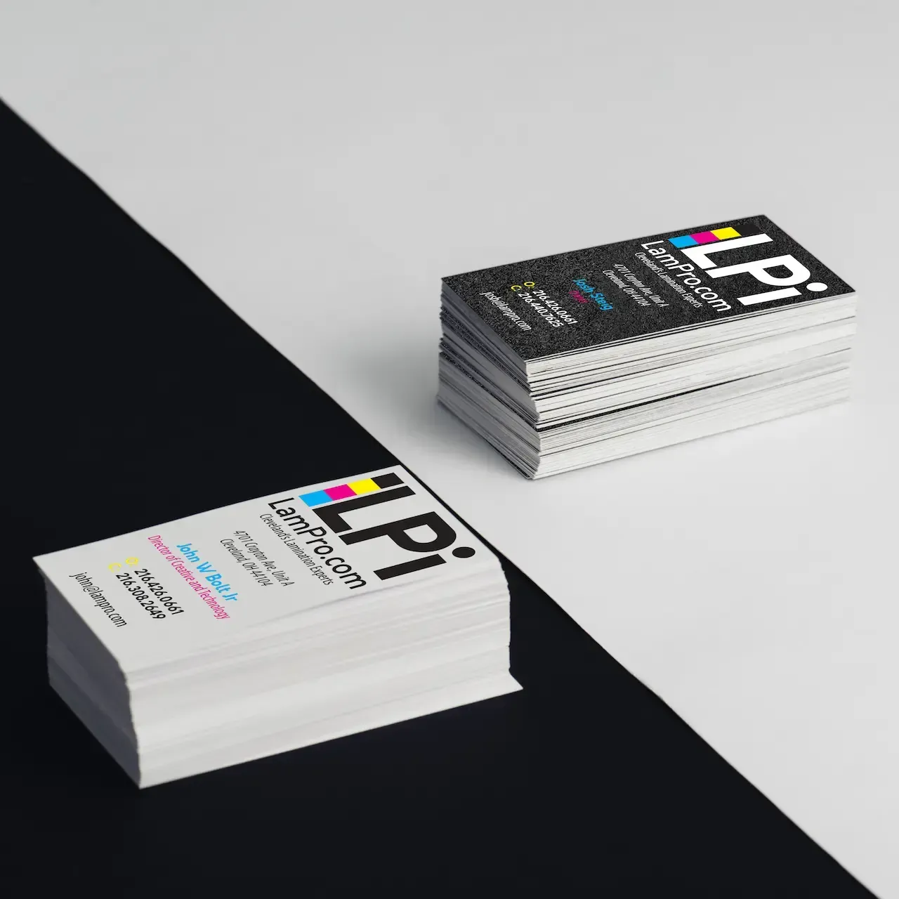 Stacks of business cards with a logo and text, on a black and white diagonal background.