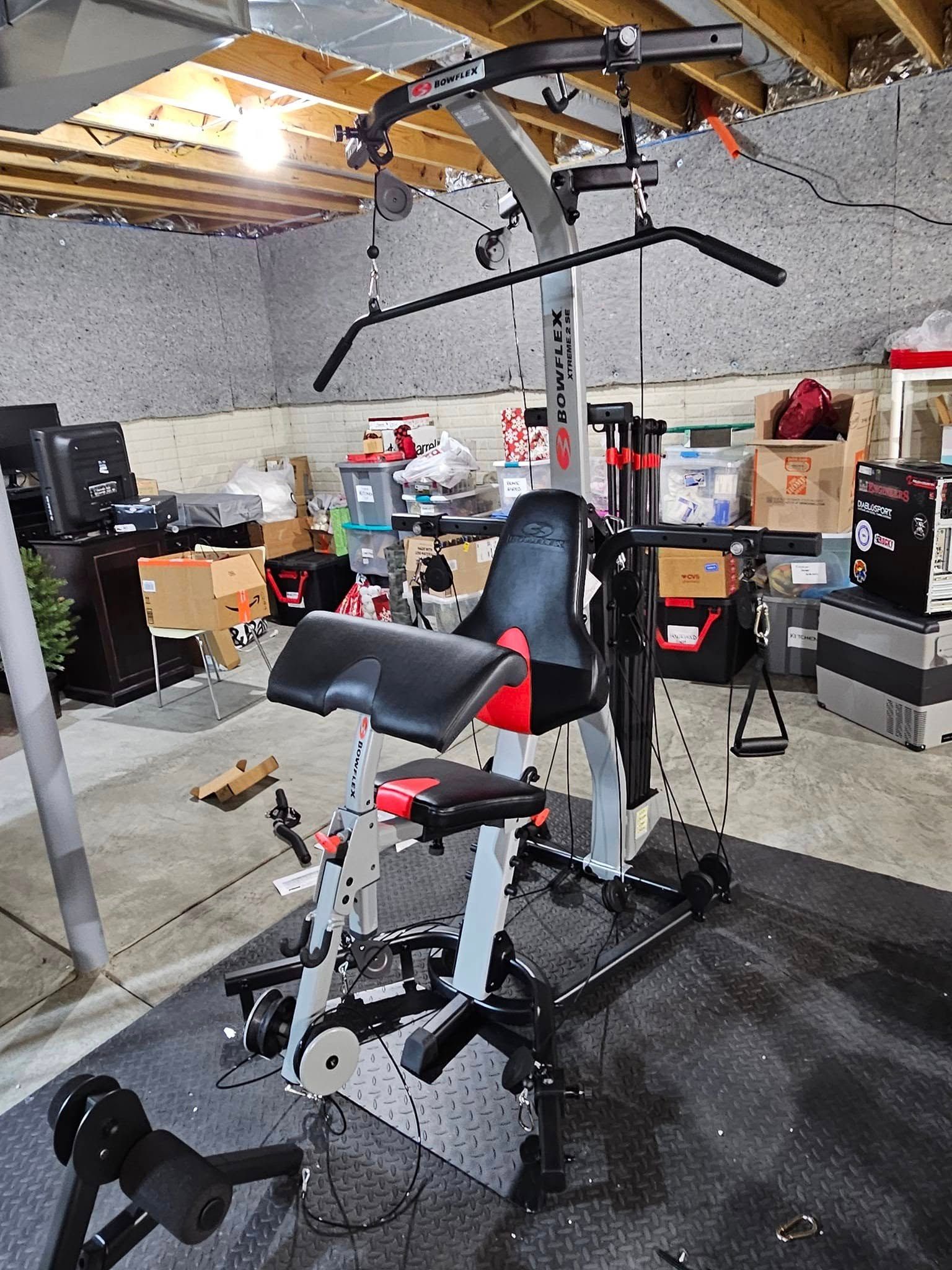 A gym machine is sitting in the middle of a garage.