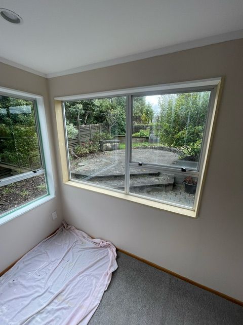 There is a Bed in the Corner of the Room with a Large Window — Lower Hutt, NZ — Complete Aluminium Maintenance Ltd