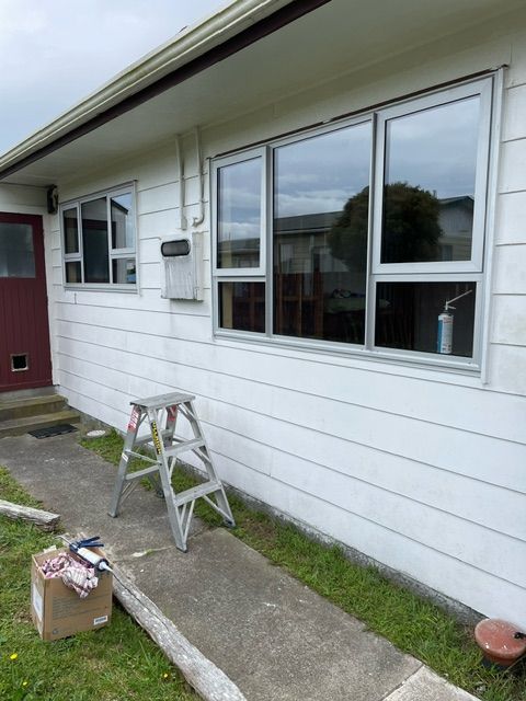 A White House with a Red Door and a Ladder in Front of it — Lower Hutt, NZ — Complete Aluminium Maintenance Ltd