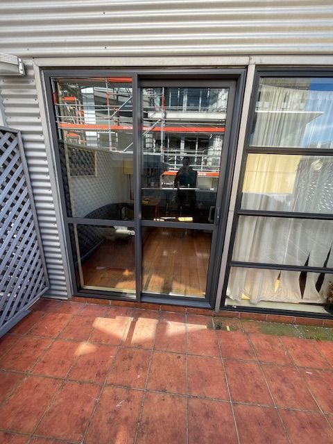 A Patio with a Sliding Glass Door Leading to a Living Room — Lower Hutt, NZ — Complete Aluminium Maintenance Ltd