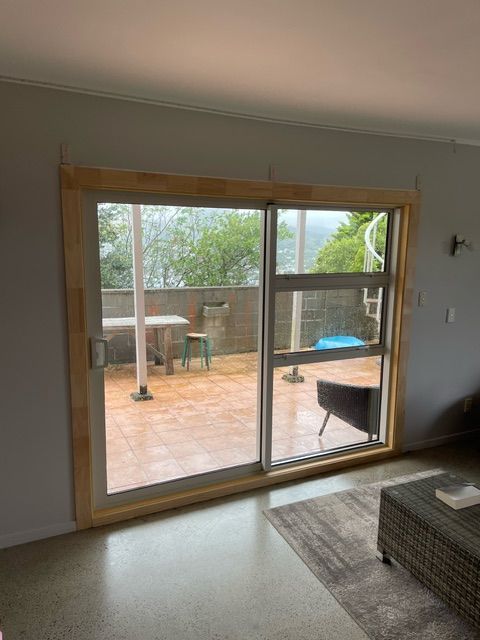 A Living Room with a Sliding Glass Door Leading to Outdoor Patio — Lower Hutt, NZ — Complete Aluminium Maintenance Ltd