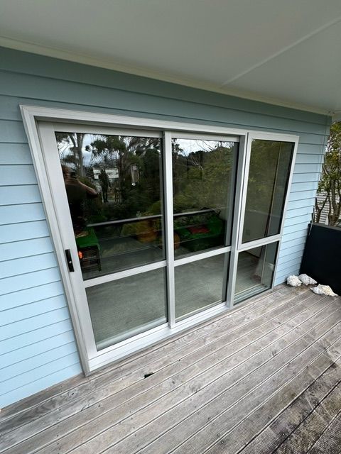 A Sliding Glass Door is Sitting on Top of a Wooden Deck — Lower Hutt, NZ — Complete Aluminium Maintenance Ltd