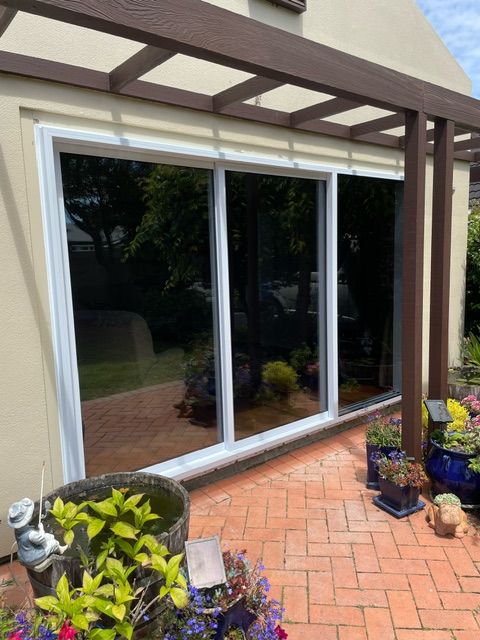 A Patio with Potted Plants and a Sliding Glass Door — Lower Hutt, NZ — Complete Aluminium Maintenance Ltd