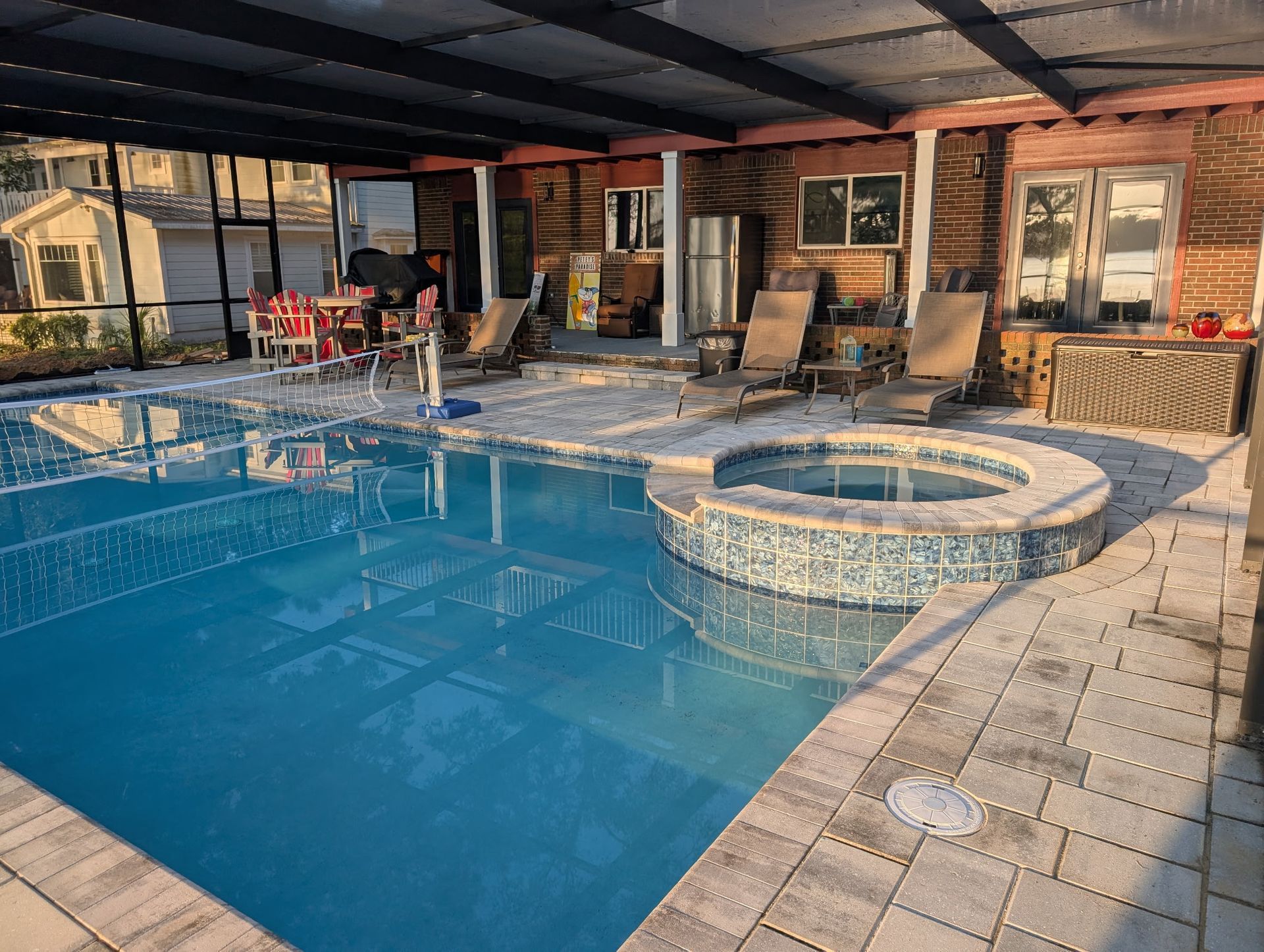Swimming pool with a hot tub, covered patio, and outdoor seating.