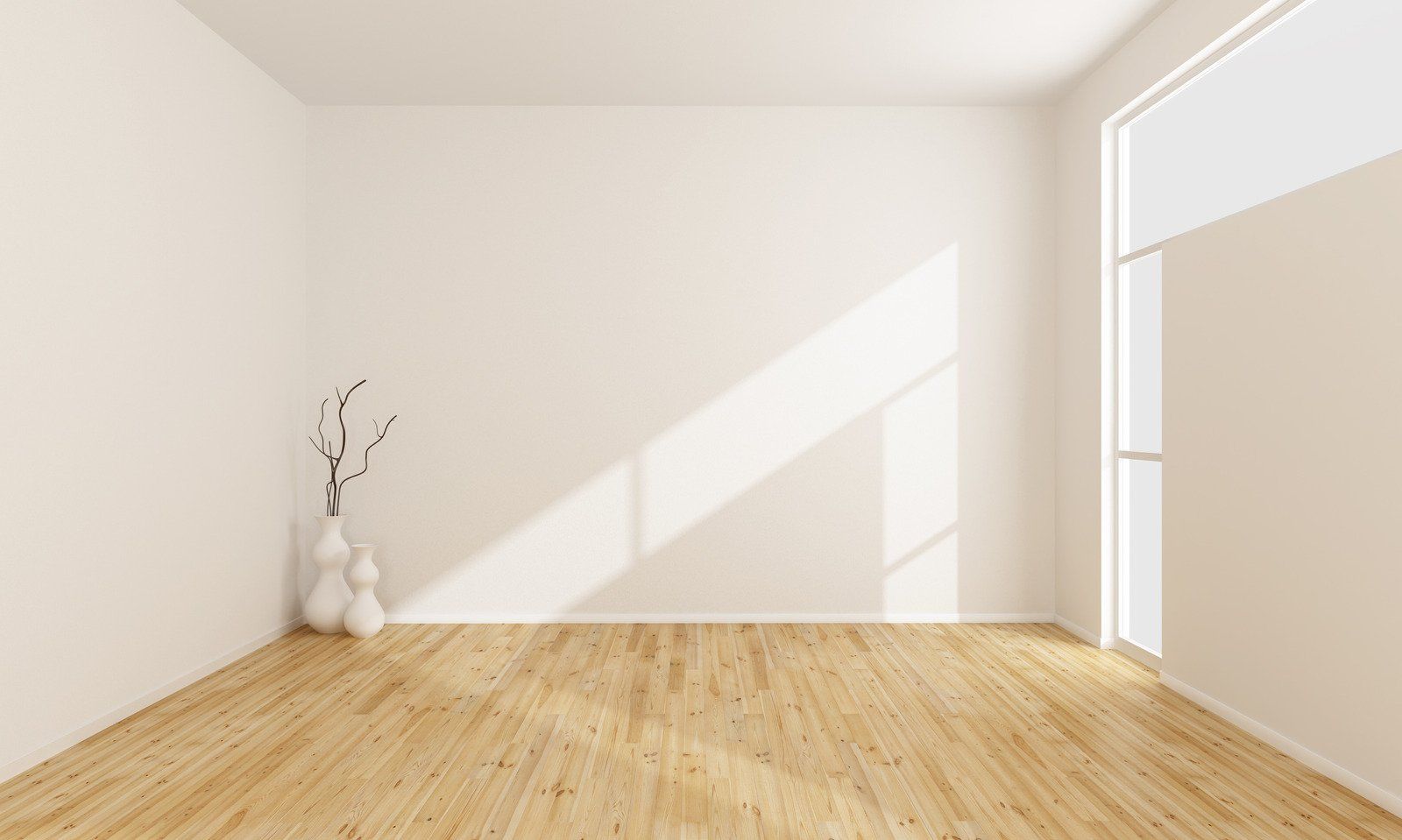 An empty room with a wooden floor and white walls.