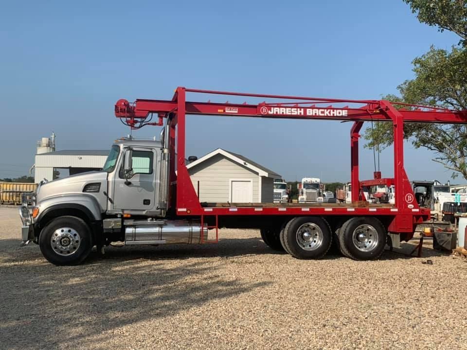 A red tow truck with a crane attached to it