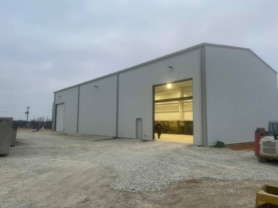 A large white building with a tractor parked in front of it.