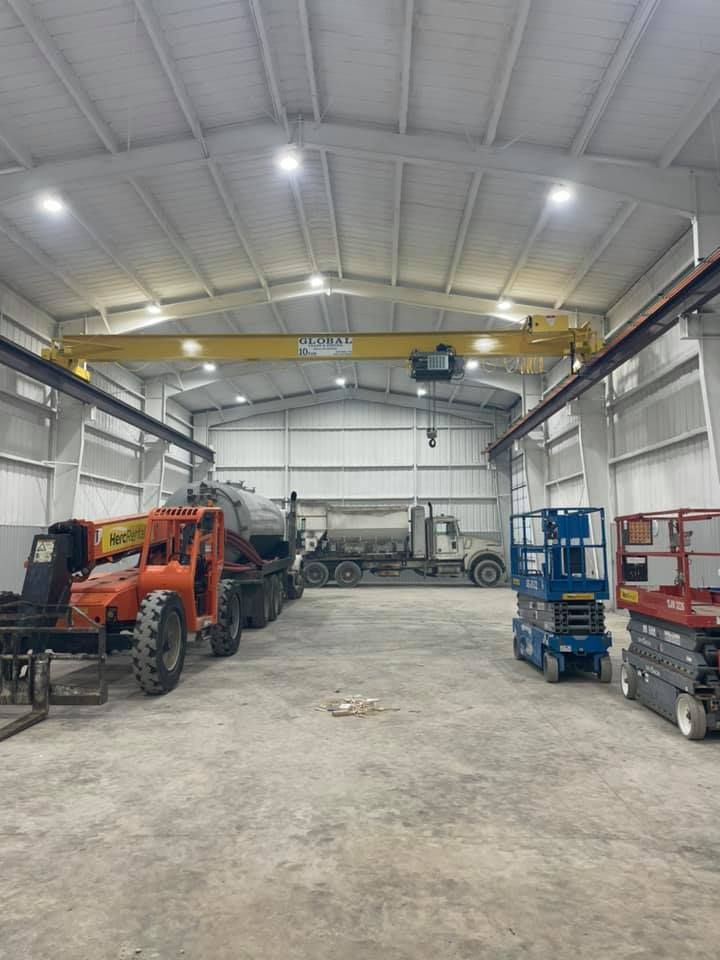 A large warehouse filled with lots of machinery and trucks.