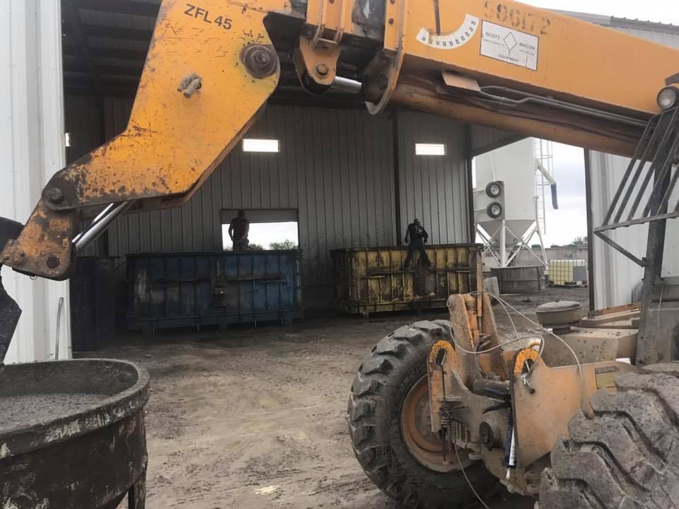 A yellow forklift is parked in front of a building.