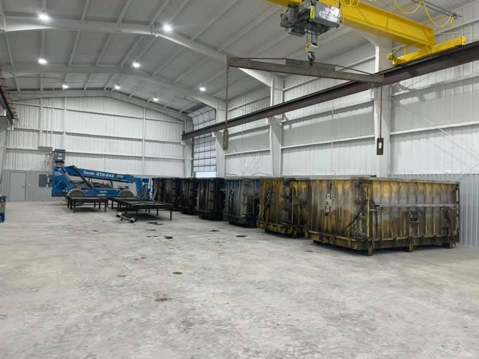 A large warehouse filled with lots of containers and a crane.