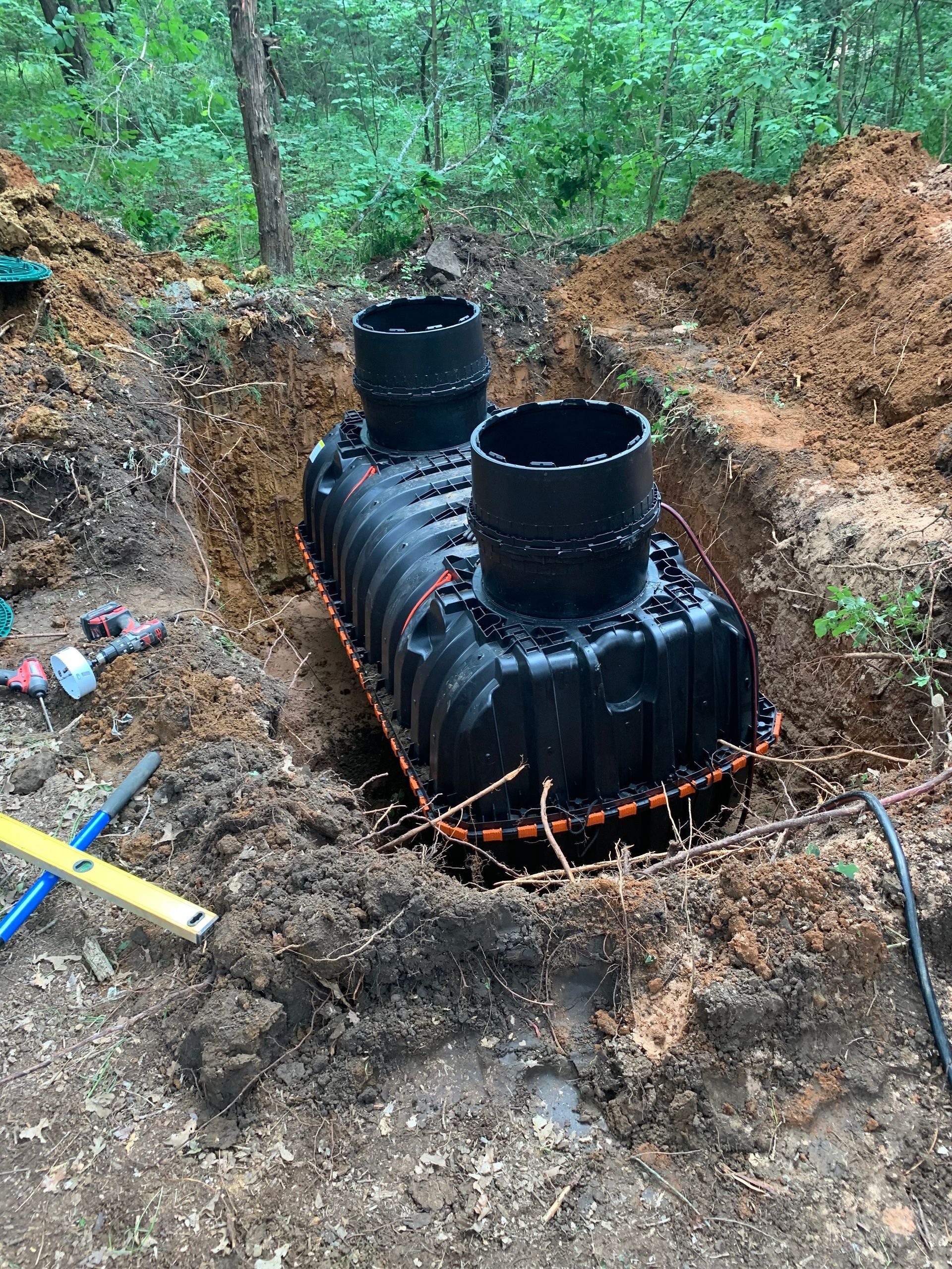 A septic tank is being installed in a hole in the ground.