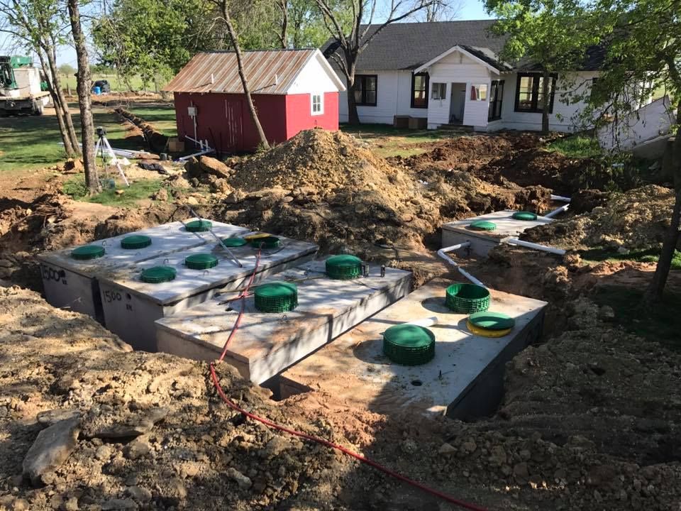 A septic system is being installed in front of a house.