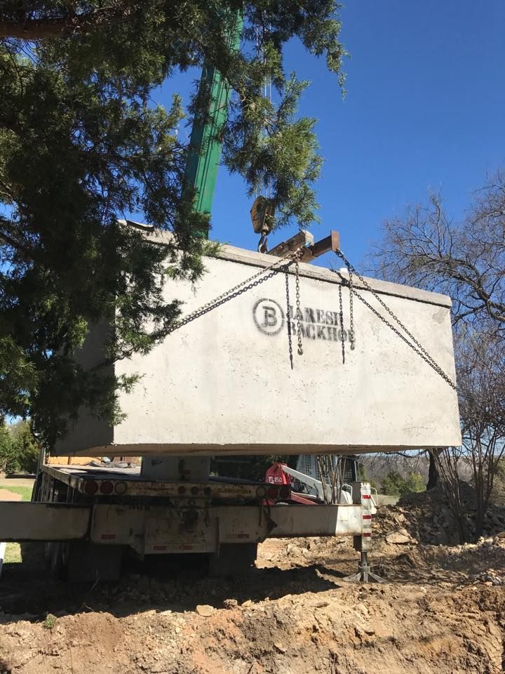 A large concrete box is being lifted by a crane.