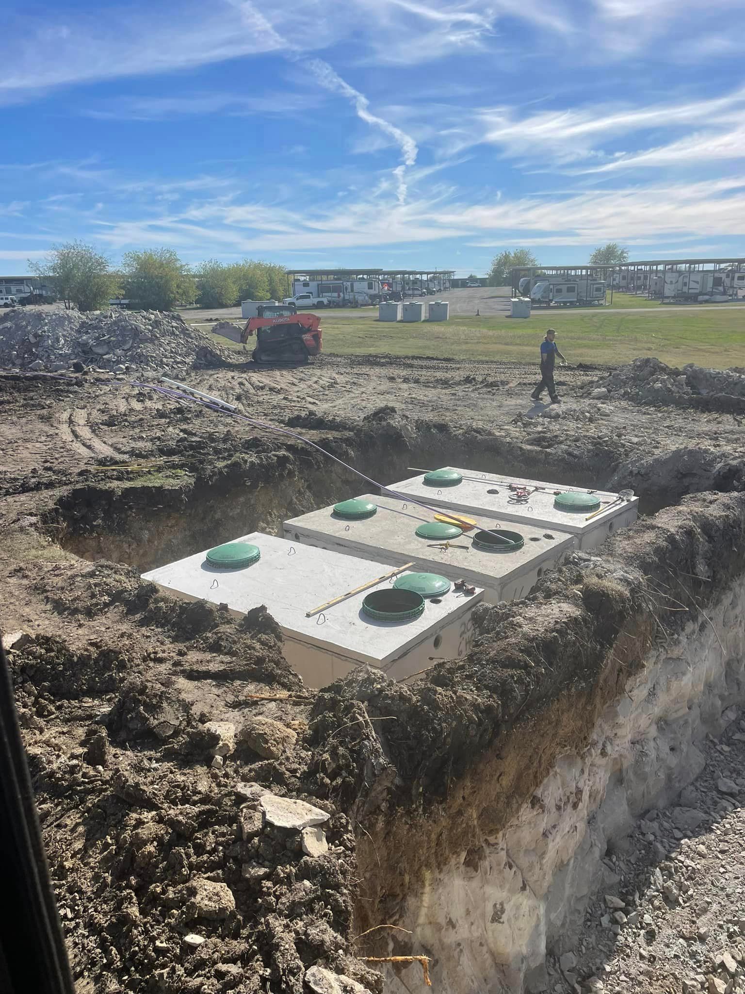 A large concrete structure is being built in a dirt field.