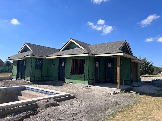 House under construction with green siding, gray roof, and unfinished pool.