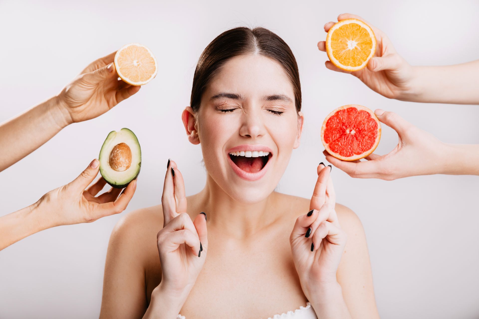 A woman is surrounded by hands holding fruits and vegetables.