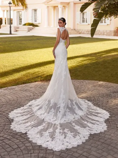 Sposa in un abito da sposa bianco in pizzo floreale con lungo strascico