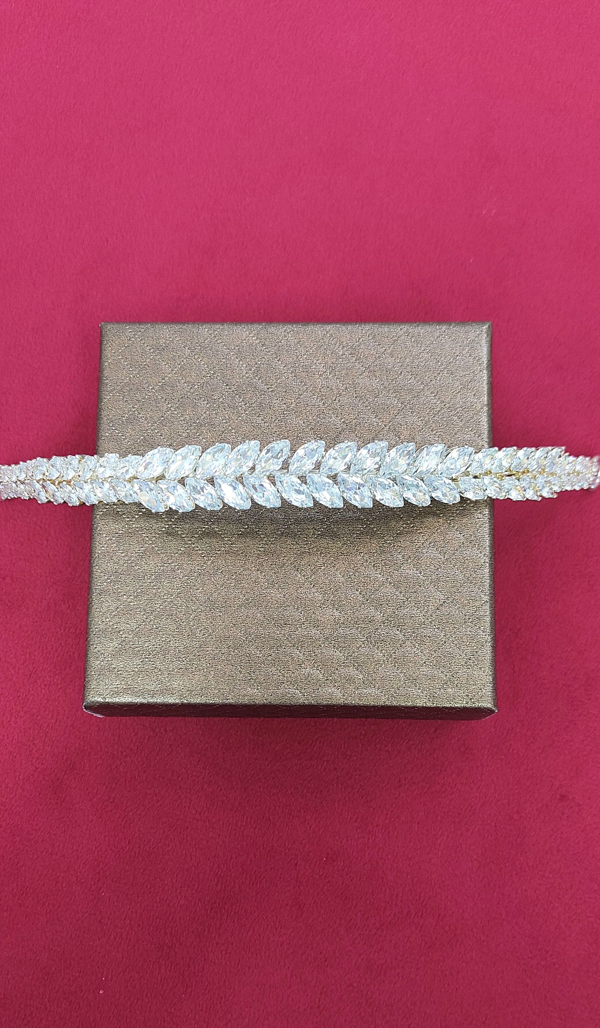 Finitura in strass argentati su una superficie rettangolare in sughero su sfondo bordeaux.