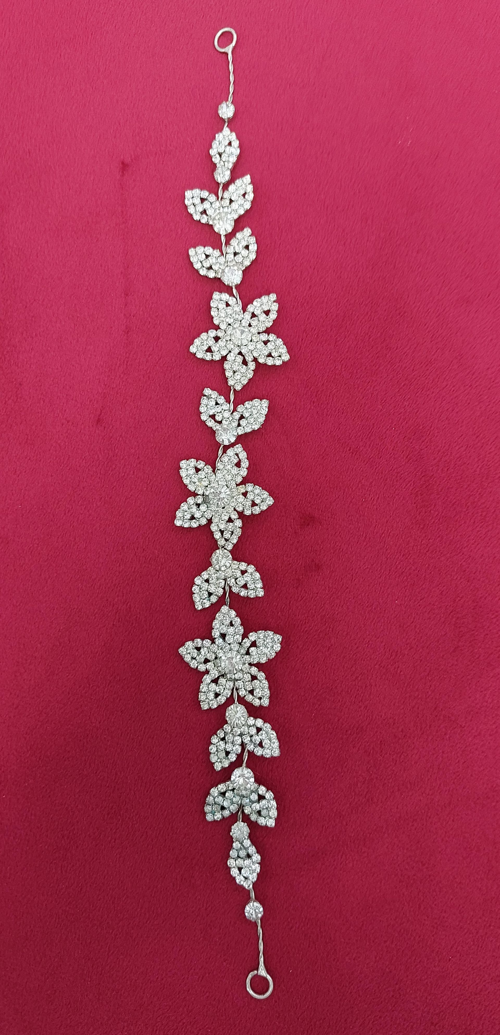 Copricapo floreale in argento su sfondo rosso.