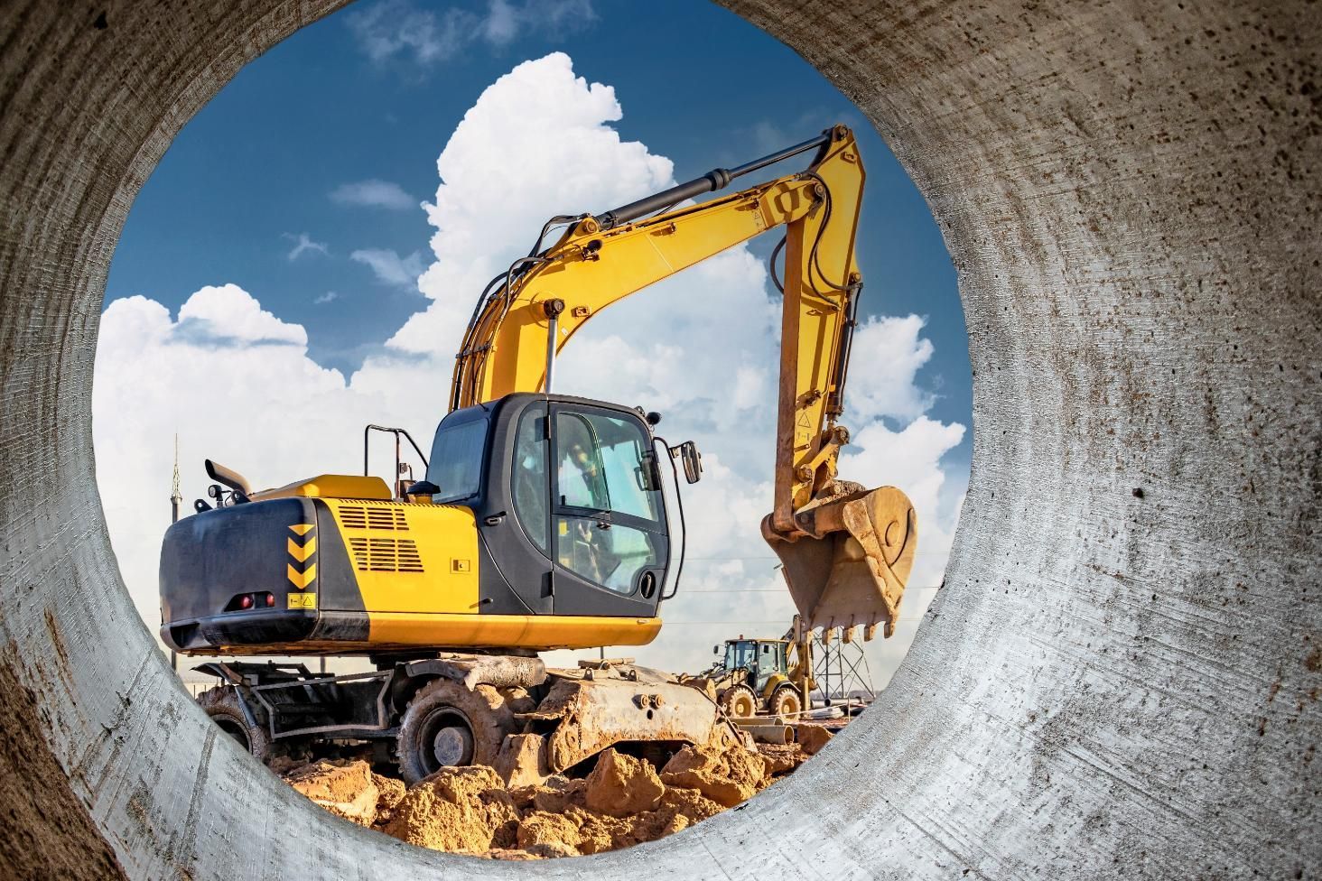 A yellow excavator is working on a construction site.