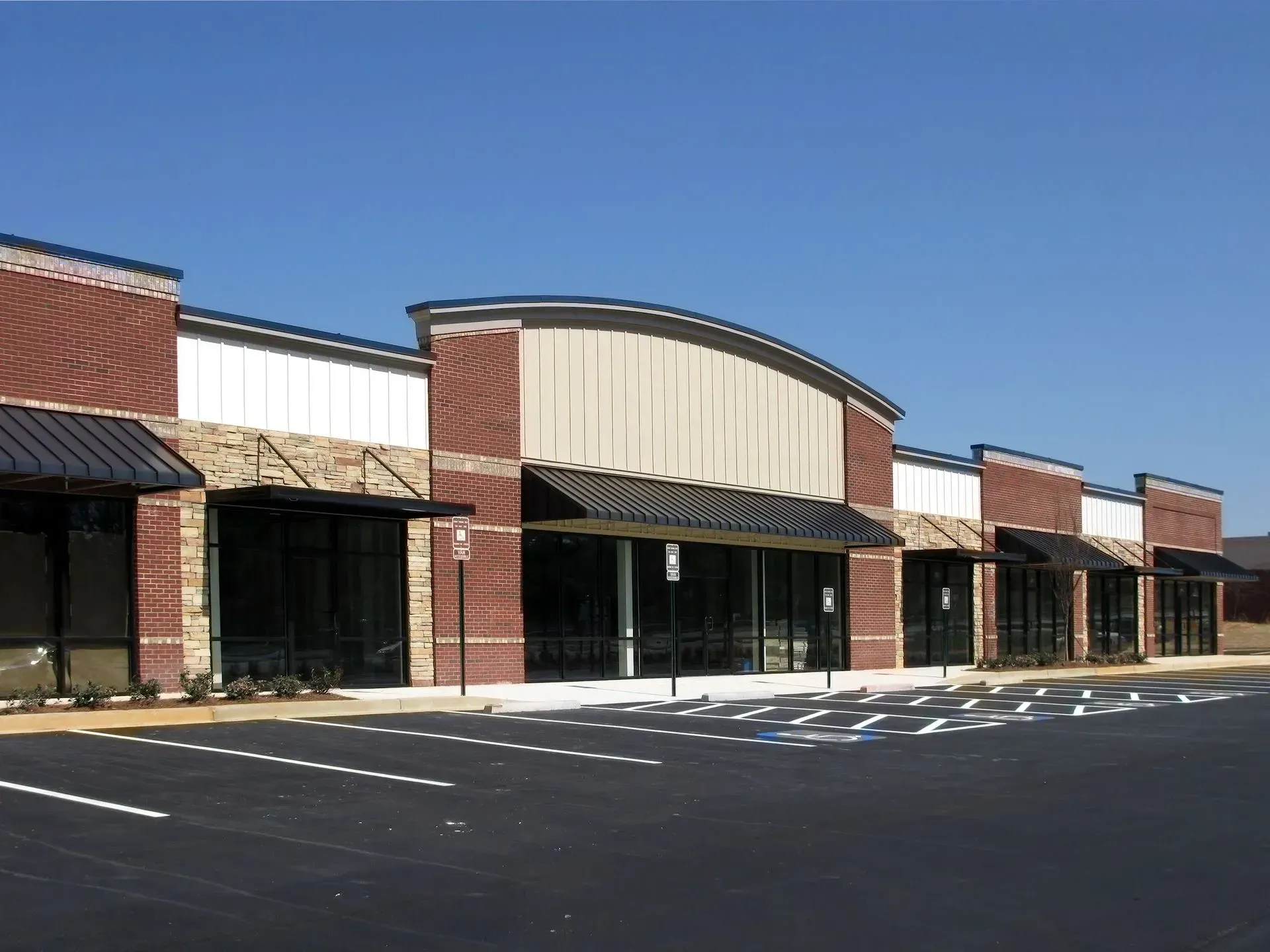 A brick building with a parking lot in front of it.