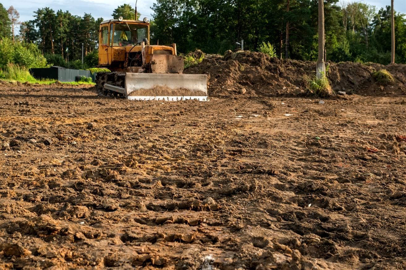 A bulldozer is working on a dirt field.